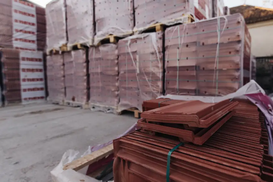 Tarimas de loseta y ladrillo emplayadas en un patio de materiales